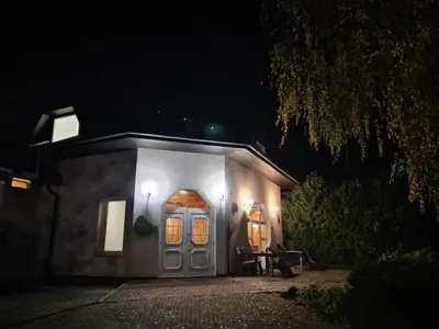 a small house with lights on the front at night at Brezov kot in Jesenice