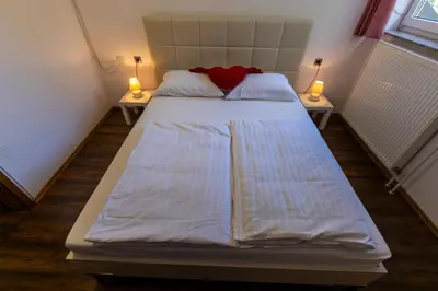 a bed in a room with two lamps on two tables at Brezov kot in Jesenice