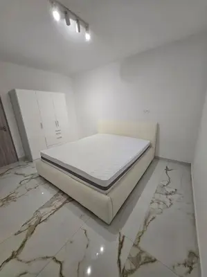 a bed sitting on the floor in a white room at Lavitas Premium in Moravče