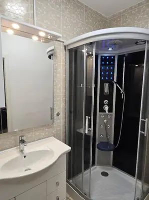 a bathroom with a shower next to a sink and a sink at Lavitas Premium in Moravče
