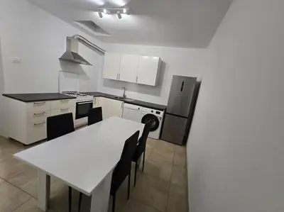 a kitchen with a table and a white table and chairs at Lavitas Premium in Moravče
