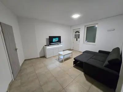 a living room with a black couch and a tv at Lavitas Premium in Moravče