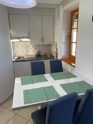 a kitchen with a white table with chairs and a tableasteryasteryasteryasteryastery at Marjetjca 40 in Moravske Toplice
