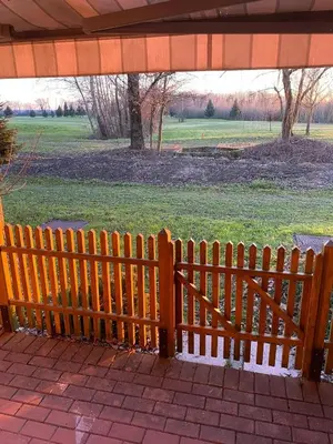 a wooden bench in a park with a field at Marjetjca 40 in Moravske Toplice
