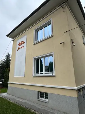 a building with two windows on the side of it at Vila Majda Elegant Apartments with Prime Location and Parking in Ljubljana