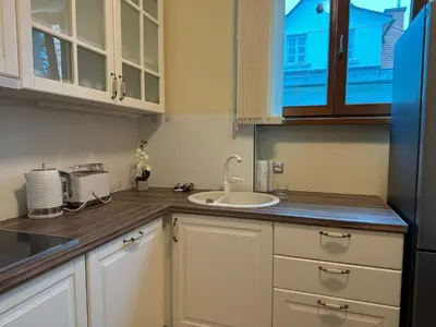 a kitchen with white cabinets and a sink and a window at Vila Majda Elegant Apartments with Prime Location and Parking in Ljubljana
