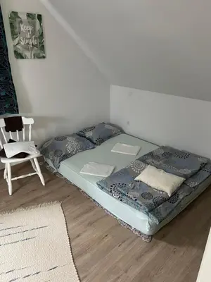 a bed sitting in a room with a chair at Holiday house Gradišče in Škofljica