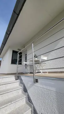a table and a chair sitting on the side of a house at Piramida Kras in Komen