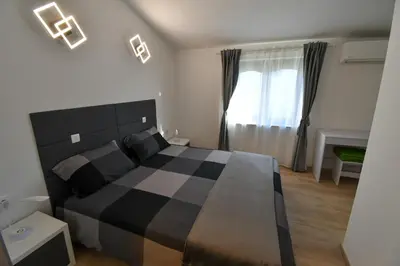 a bedroom with a black and white bed and a window at Piramida Kras in Komen