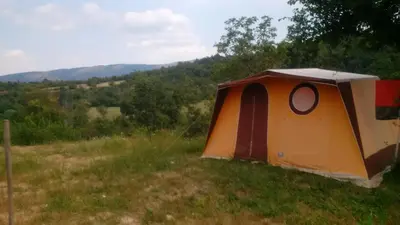 a tent sitting in the grass in a field at Osterija Na Planinci in Divača