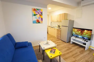 a living room with a blue couch and a kitchen at Rezidenca Erjavec in Notranje Gorice