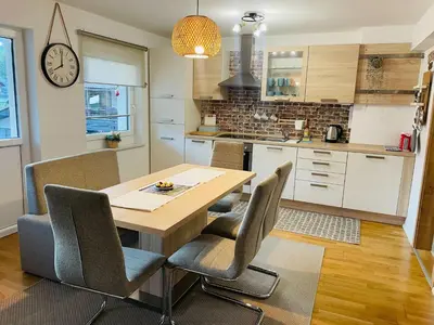 a kitchen with a wooden table and chairs at Apartment Zala with Sauna in Kranjska Gora