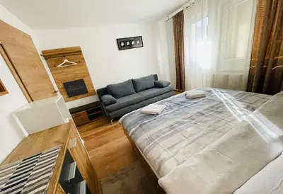 a small bedroom with a bed and a couch at Apartment Zala with Sauna in Kranjska Gora