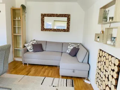 a living room with a couch and a mirror at Apartment Zala with Sauna in Kranjska Gora