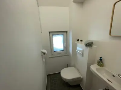 a white bathroom with a toilet and a window at Apartment Zala with Sauna in Kranjska Gora