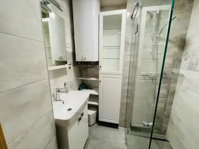 a white bathroom with a sink and a shower at Apartment Zala with Sauna in Kranjska Gora