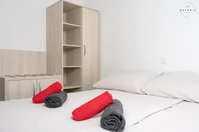 a bedroom with two red pillows on a bed at Meloria Apartments in Veržej