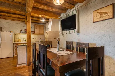 a kitchen with a wooden table and a refrigerator at Vineyard Cottage Skatlar 2 in Srednje Grčevje