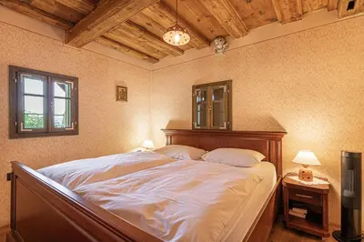 a bedroom with a large bed with a wooden headboard at Vineyard Cottage Skatlar 2 in Srednje Grčevje