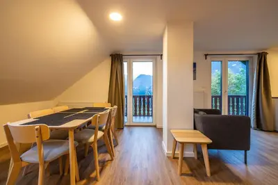 a dining room with a table and chairs at Via Alpina Apartments with sauna in Mojstrana