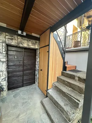 a garage with a wooden door and stairs at PERLE d ARCONI in Renče