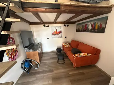 a living room with a orange couch in a room at PERLE d ARCONI in Renče