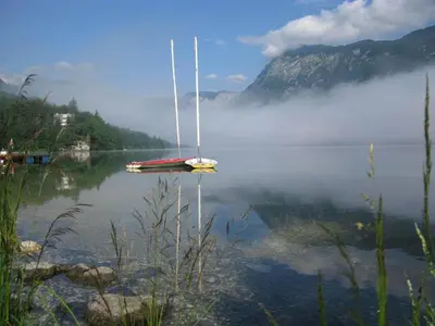 a boat sitting in the middle of a body of water at Apartment Šporar in Bohinj