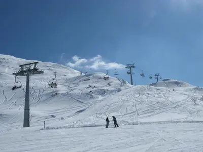 two people on a ski slope with a ski lift at Apartment Šporar in Bohinj