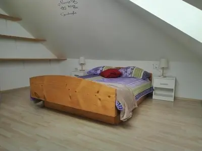 a bedroom with a wooden bed in a attic at Panoramic View in Postojna