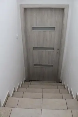 a wooden door in a room with stairs at Panoramic View in Postojna