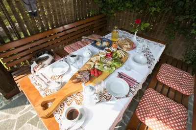 a table with a plate of food on top of it at Apartmaji Katrnjek in Bohinj