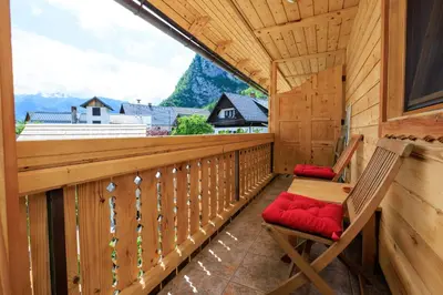 a balcony of a cabin with a table and chairs at Apartmaji Katrnjek in Bohinj