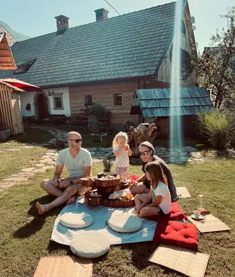 a group of people sitting around a picnic blanket at Apartmaji Katrnjek in Bohinj