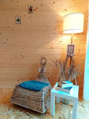a room with a rattan chair and a table with a lamp at HERBALIJA Apartment Herbalija - sorrounded by Nature in Podčetrtek