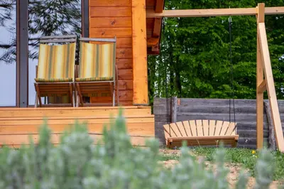 two chairs sitting on the porch of a cabin at Log cabin Silec in Šmarje pri Jelšah