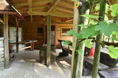 an outside view of a wooden cabin with a table at Log cabin Silec in Šmarje pri Jelšah
