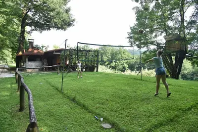 two people playing a game of volleyball in a park at Log cabin Silec in Šmarje pri Jelšah
