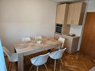 a kitchen with a wooden table and white chairs at Apartment Josipina in Preddvor