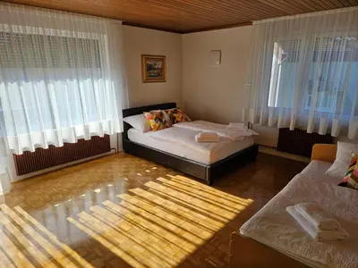 a bedroom with two beds and a couch and windows at Apartment Josipina in Preddvor