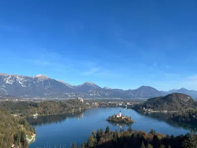 an island in the middle of a lake with mountains at TB7 Bled in Bled