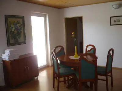 a dining room with a table and chairs and a window at Apartmaji in sobe Kocjančič in Podčetrtek