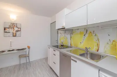 a kitchen with white cabinets and a sink at Apartma Bled in Bled