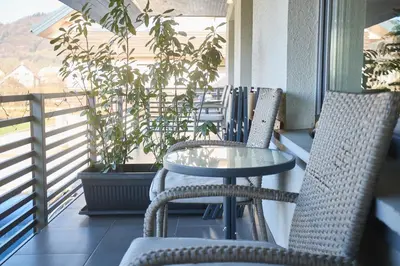 a table and chairs on a balcony with a window at Apartma Bled in Bled