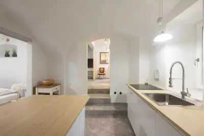 a kitchen with white walls and a wooden counter top at Karlovška Duplex Urban Apartment in Ljubljana