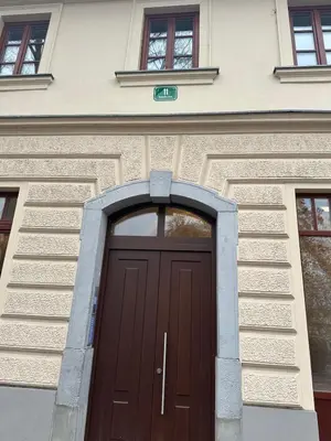 a brown door on a building with windows at Karlovška Duplex Urban Apartment in Ljubljana