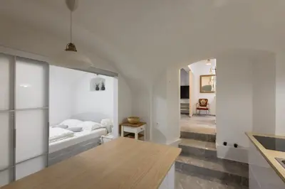 a kitchen and living room with a bed and a table at Karlovška Duplex Urban Apartment in Ljubljana