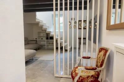 a living room with a staircase and a chair at Karlovška Duplex Urban Apartment in Ljubljana