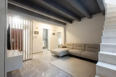 a living room with a couch and a chair at Karlovška Duplex Urban Apartment in Ljubljana