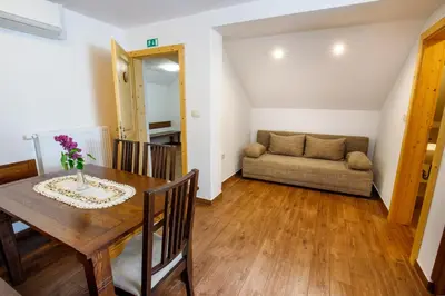 a dining room with a table and a couch at Kmetija Na Čendavš in Cerkno