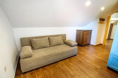 a living room with a couch and a wooden floor at Kmetija Na Čendavš in Cerkno
